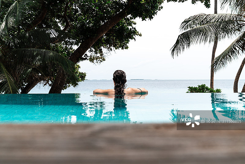 年轻女子在游泳池里放松图片素材