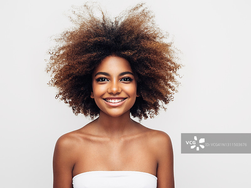 漂亮的微笑着的卷发女孩图片素材