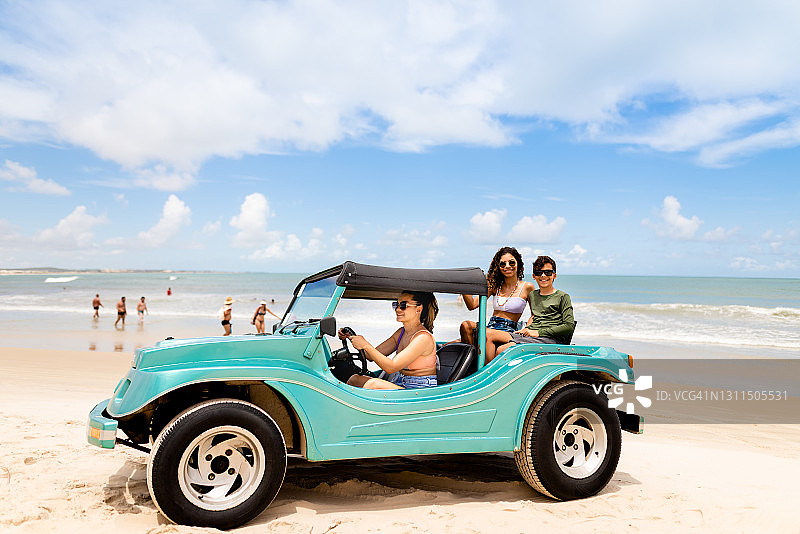 母亲开着沙滩车带两个孩子兜风图片素材
