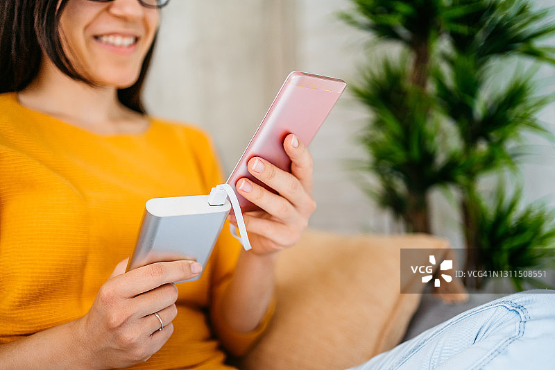 女人用充电宝给手机充电图片素材