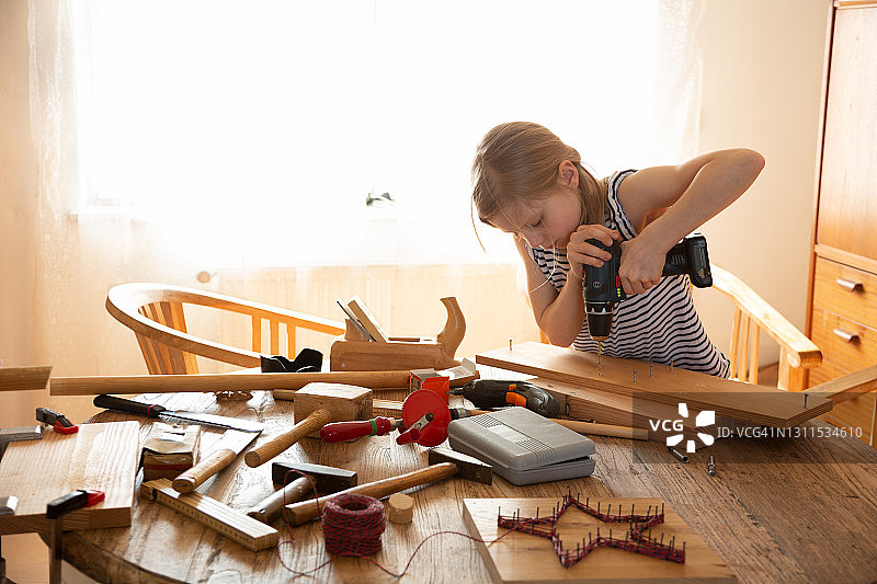 女孩用电动螺丝刀做DIY项目图片素材
