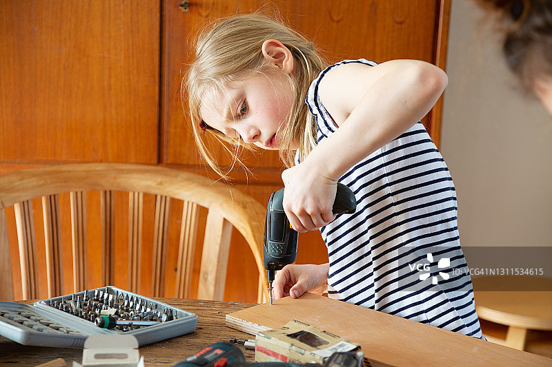 女孩用电动螺丝刀做DIY项目图片素材