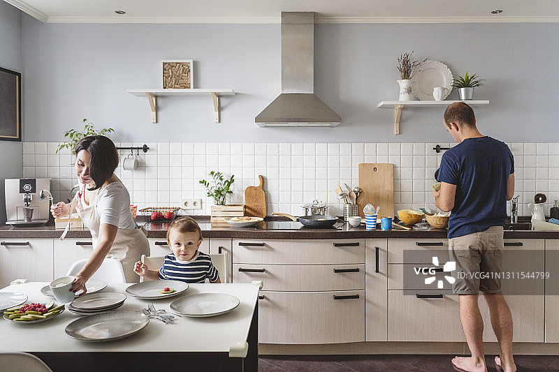 父母和可爱的儿子在厨房准备食物图片素材
