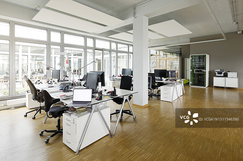 空荡荡的办公室里桌子上的笔记本电脑图片素材