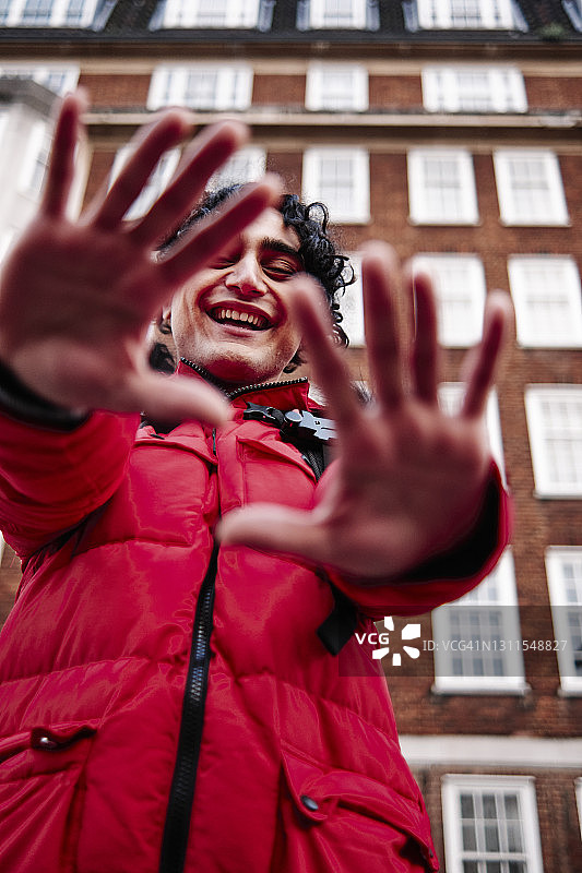 快乐的男人对着建筑物展示双手图片素材