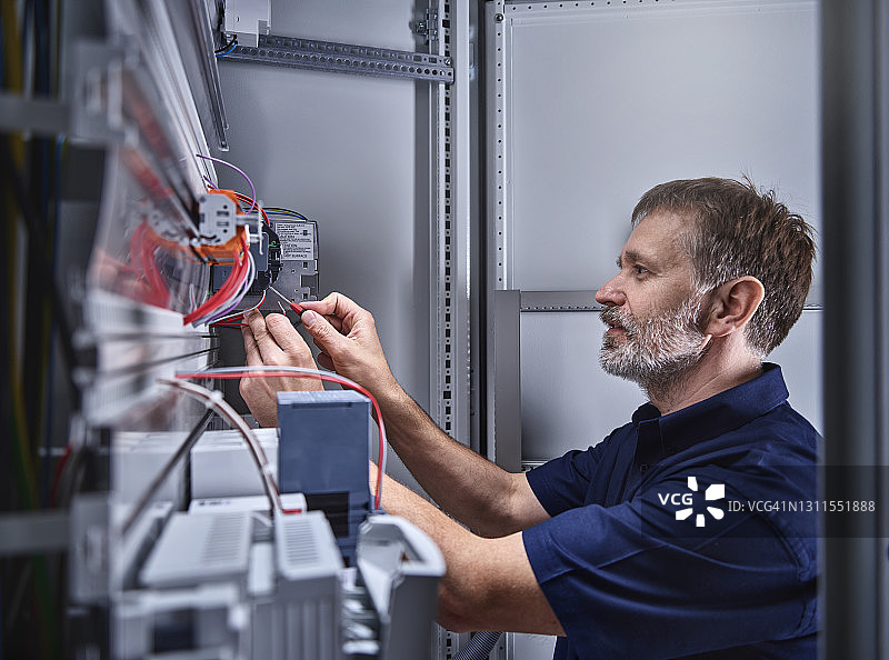 男电工在电气车间检查电源图片素材