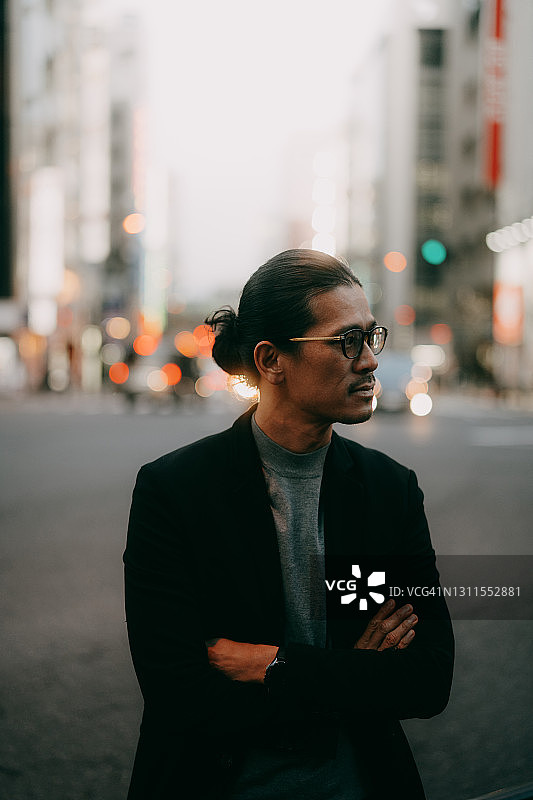 东京黄昏时分戴眼镜的扎马尾日本男人图片素材