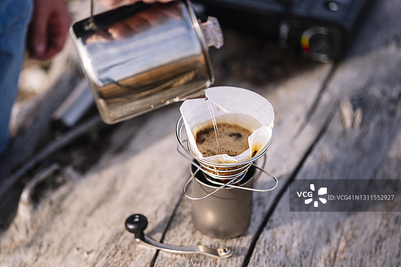 男人用烧水壶倒水准备咖啡图片素材