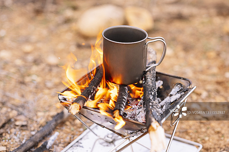 燃烧的木柴上的咖啡杯图片素材
