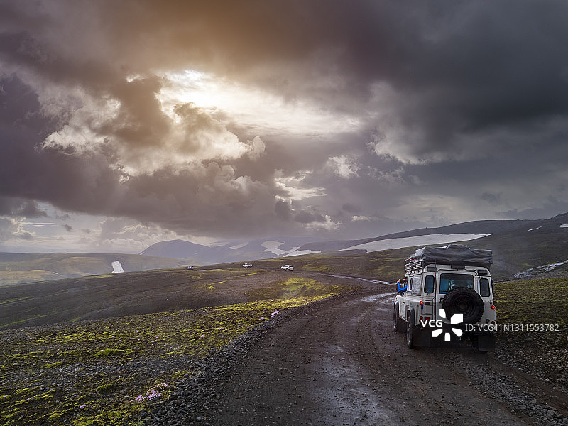 Fjallabak自然保护区偏远土路上越野车行驶时上空的壮丽天空图片素材