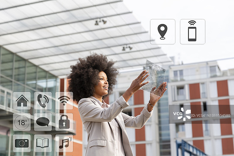 在户外使用带有图标的透明数字平板电脑的女商人图片素材