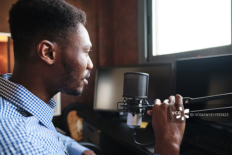中年网红在家中播客时手持麦克风图片素材