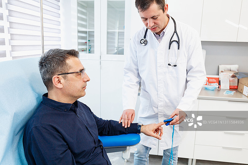 医生使用脉搏血氧仪检查血氧饱和度图片素材