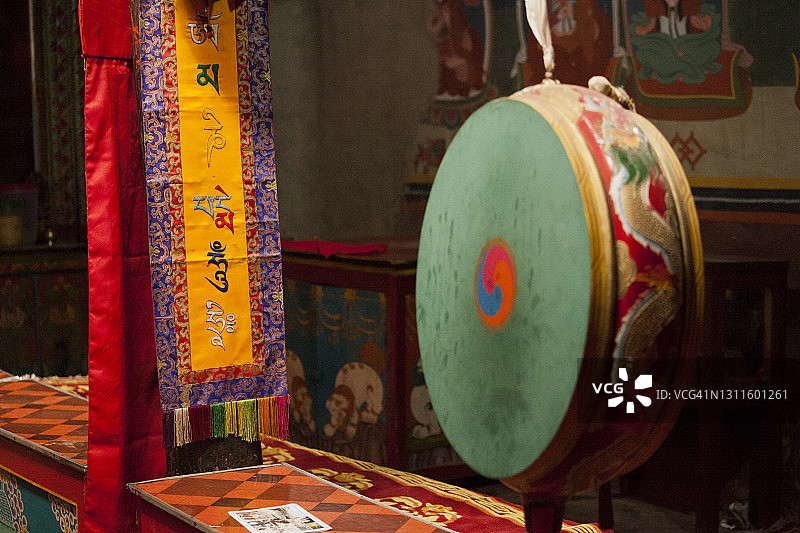 木斯塘藏族聚居区卡格本尼村寺庙中的佛教锣和藏文装饰旗帜特写图片素材