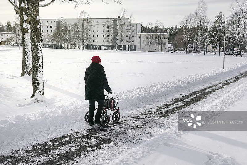 在冬天使用助行器的老年妇女图片素材