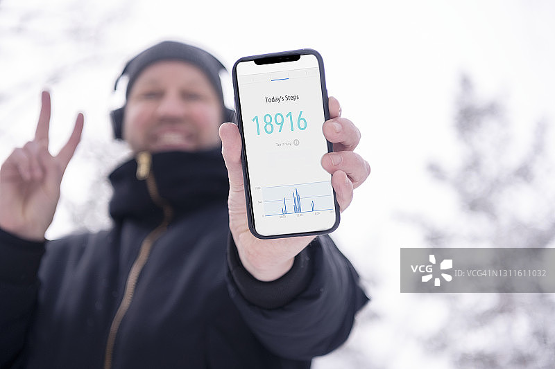 男人拿着智能手机展示步数追踪器图片素材
