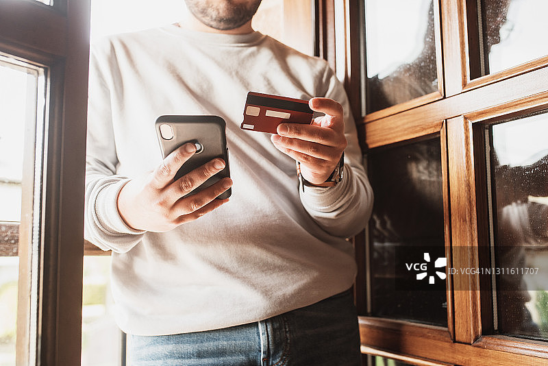 手持信用卡和智能手机的人图片素材