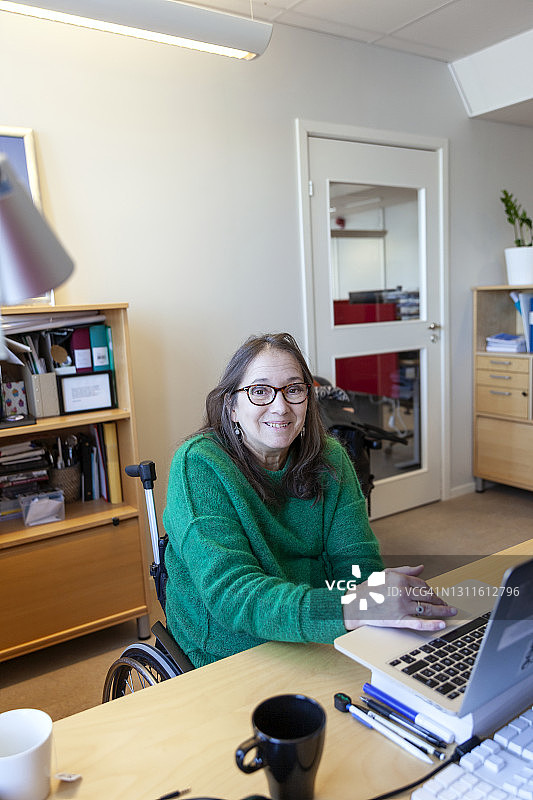 在办公室工作的残疾妇女图片素材