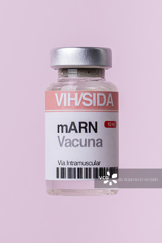 粉红色背景上的艾滋病毒mRNA疫苗瓶（西班牙语标签文本）图片素材