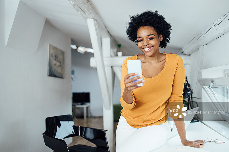 下班后使用智能手机的非洲裔女子肖像图片素材