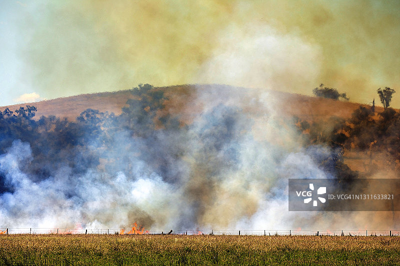 草地火灾、森林火灾、灌木丛火灾烟云、农场、树木和山脉图片素材