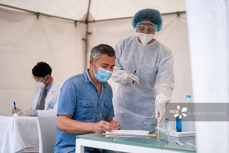 男人在接受PCR新冠检测时签署表格图片素材
