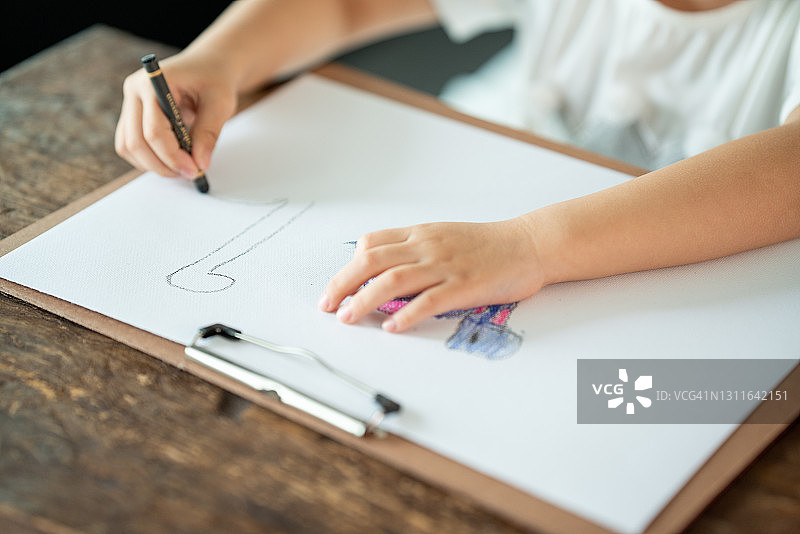 女孩们在木桌上嬉戏绘画图片素材