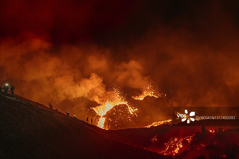 在冰岛观看火山喷发的人们图片素材