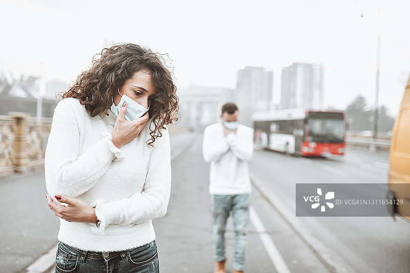 市民因空气污染窒息并在城市户外佩戴口罩图片素材