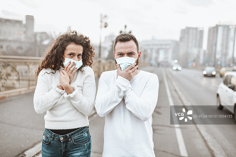 情侣展示城市中心恶劣的居住条件和低空气质量图片素材