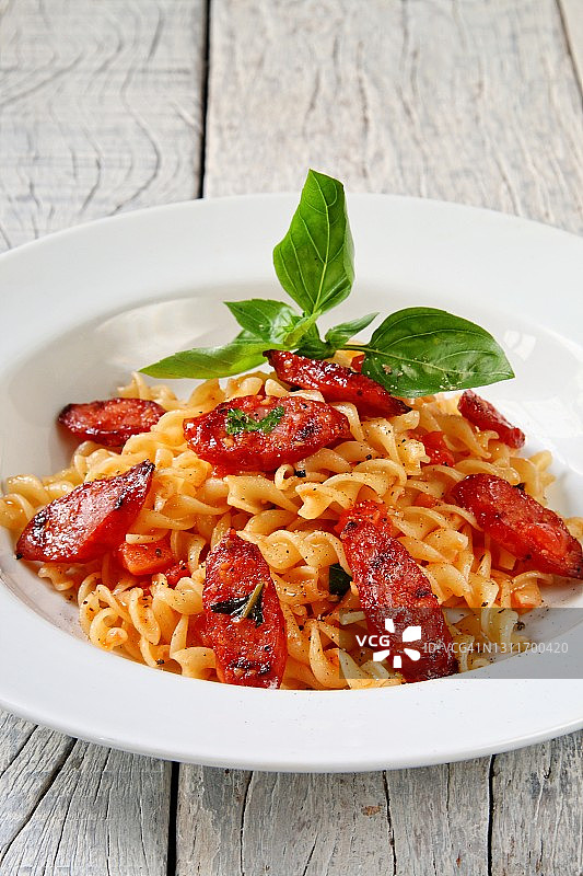 配酱汁和意大利辣香肠片的意大利宽面图片素材