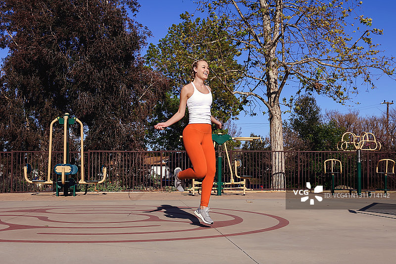 在公园跳绳的年轻女人图片素材