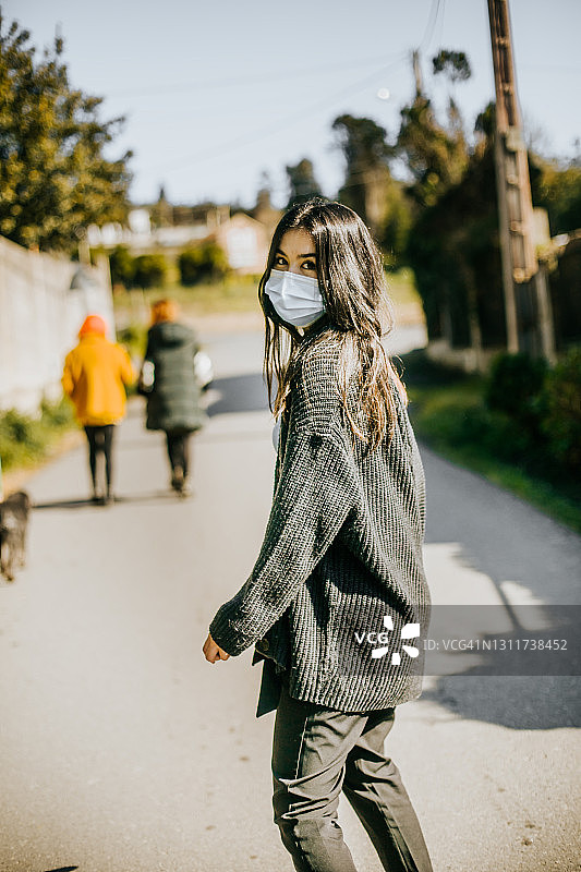 戴着防护口罩看向镜头的年轻女人图片素材