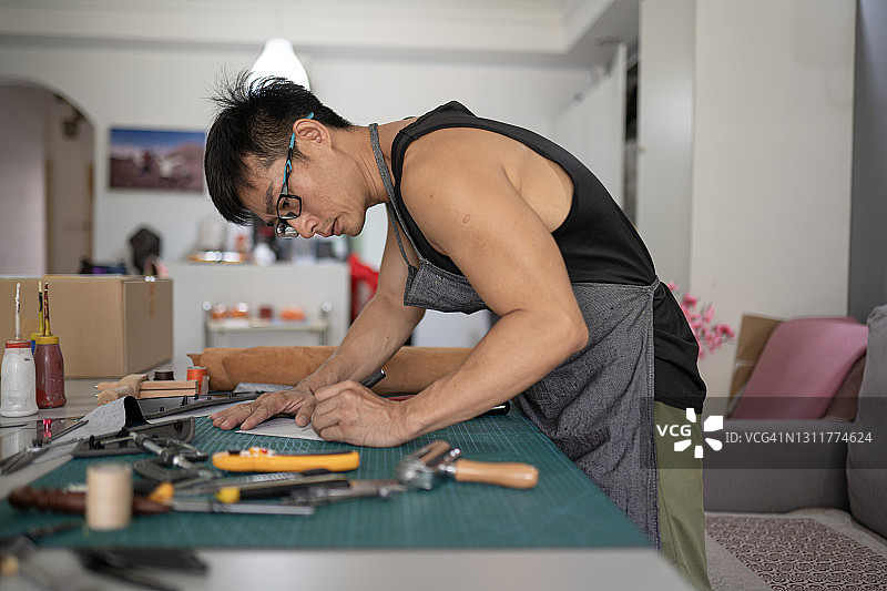 正在裁剪皮革样式的亚洲男人图片素材