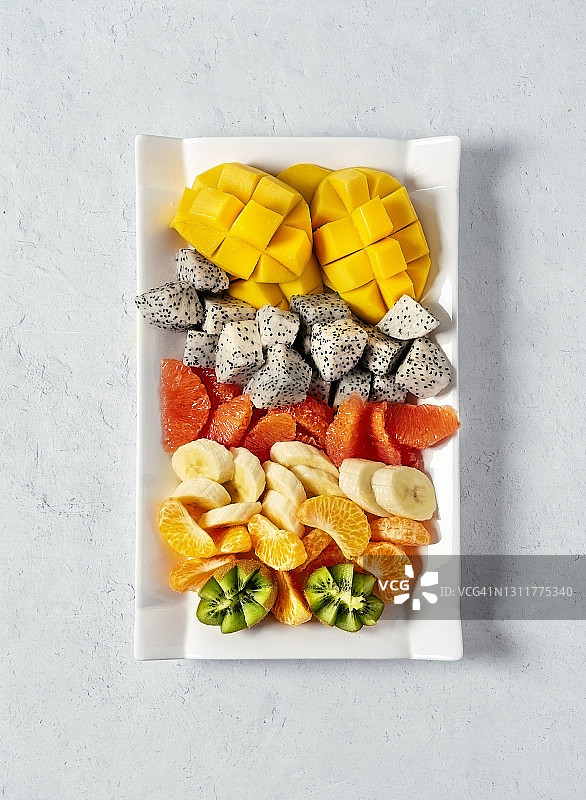 白色背景盘子里的热带水果碎图片素材