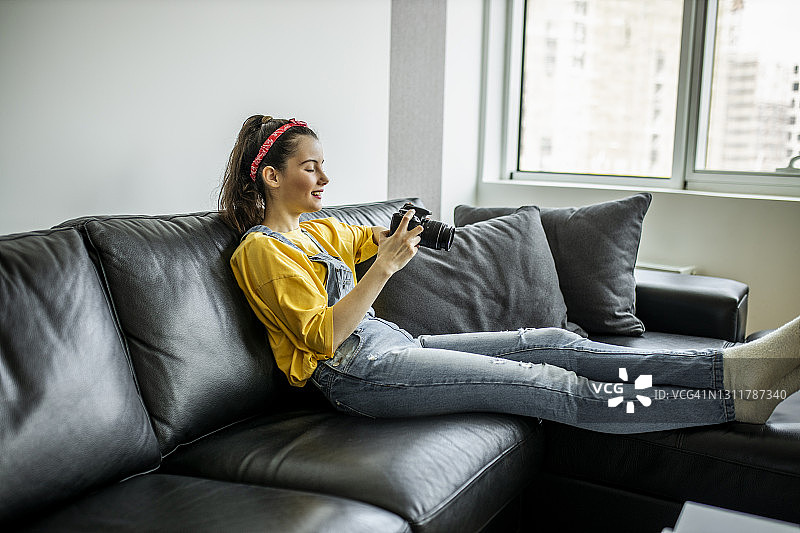 女性休息并查看相机中的照片图片素材