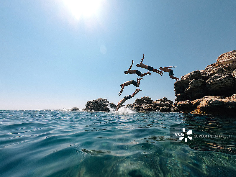 年轻男子从海中岩石跳水——多重影像效果图片素材