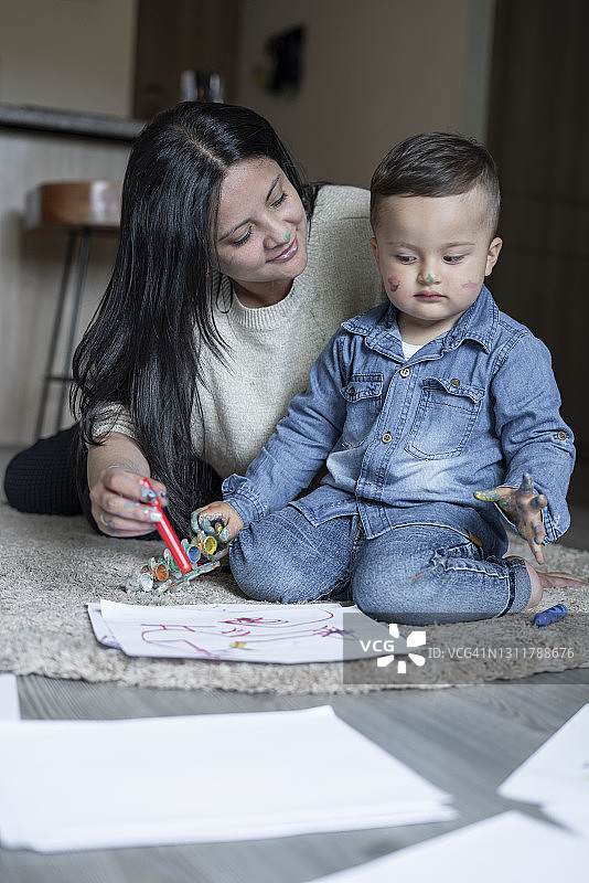 单身母亲和1到2岁的宝宝在客厅里玩耍、绘画的美好时光图片素材