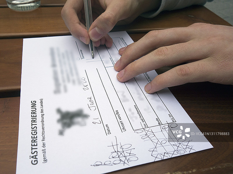 顾客在餐厅饮酒前填写强制性的新冠病毒客人登记表（含虚假信息），巴伐利亚，德国，2020年图片素材