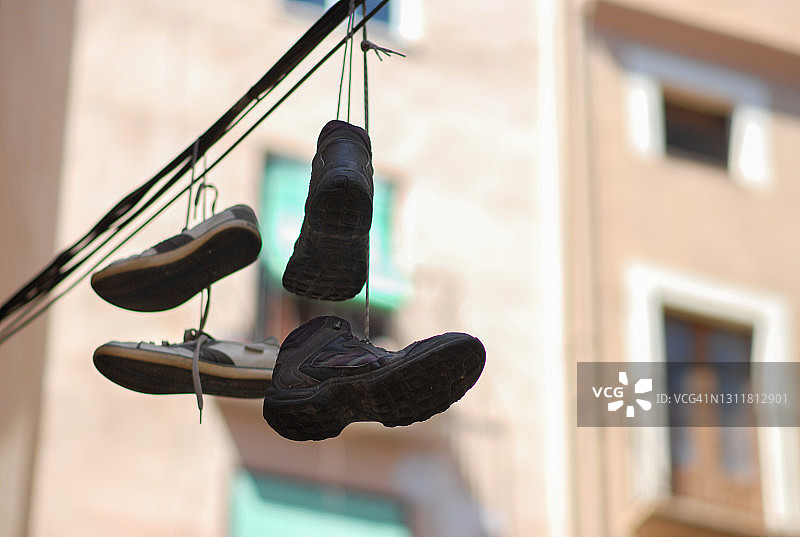 巴塞罗那城市中悬挂在电缆上的靴子图片素材