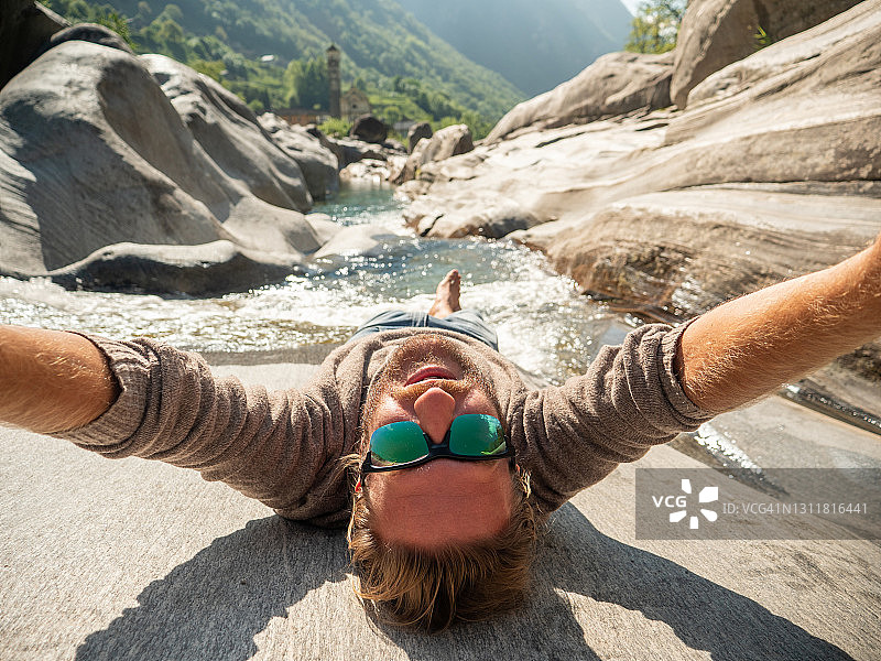 一名男子在春天于河边自拍，倒置视角图片素材