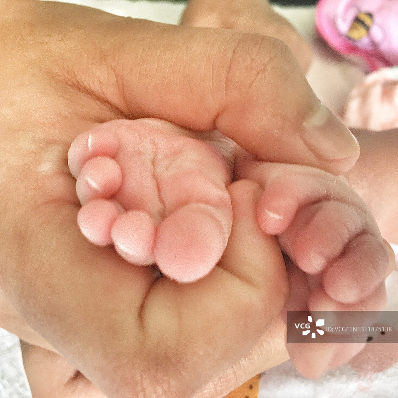 家长手托着婴儿的脚图片素材