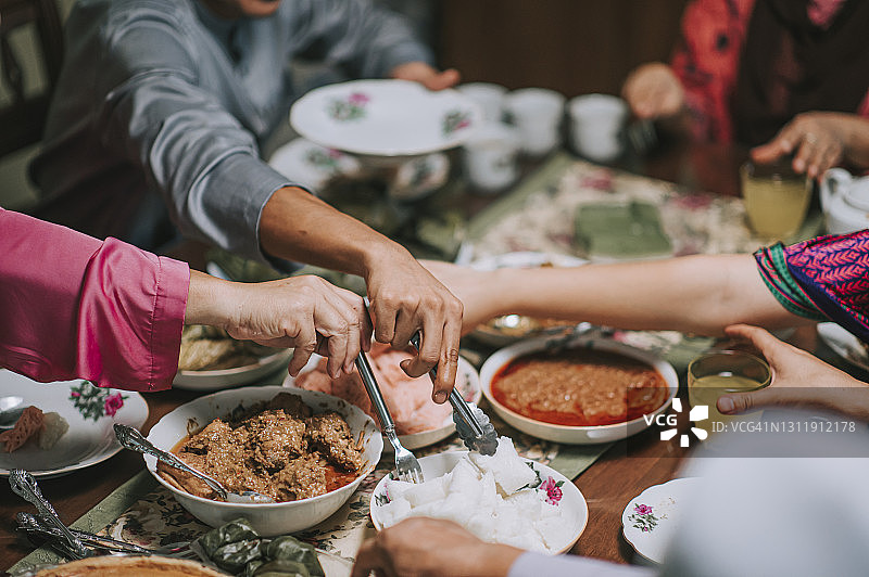 马来西亚家庭在家中享用开斋节团圆晚餐，品尝各种马来美食图片素材