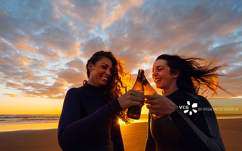 在海滩上喝酒的快乐女士图片素材