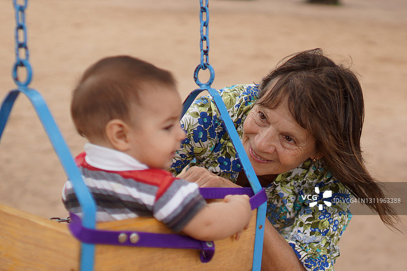 祖母与孙子在秋千上玩耍图片素材
