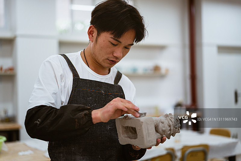 中国男孩在教室里雕刻手工艺术品图片素材