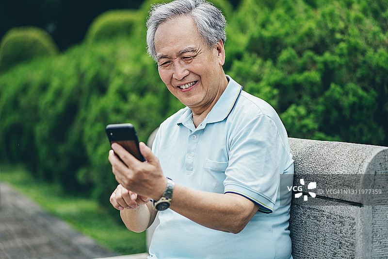 手持手机的微笑老年男人图片素材