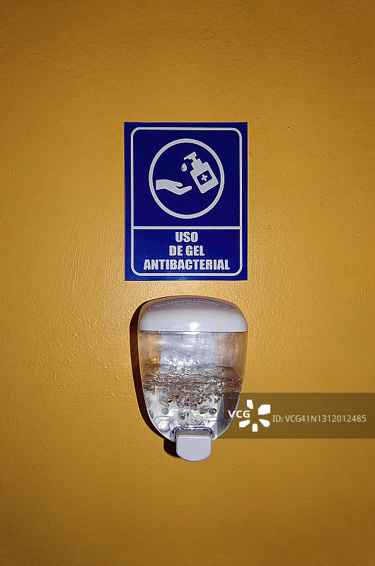 西班牙语新冠肺炎健康安全标志和抗菌凝胶分配器图片素材