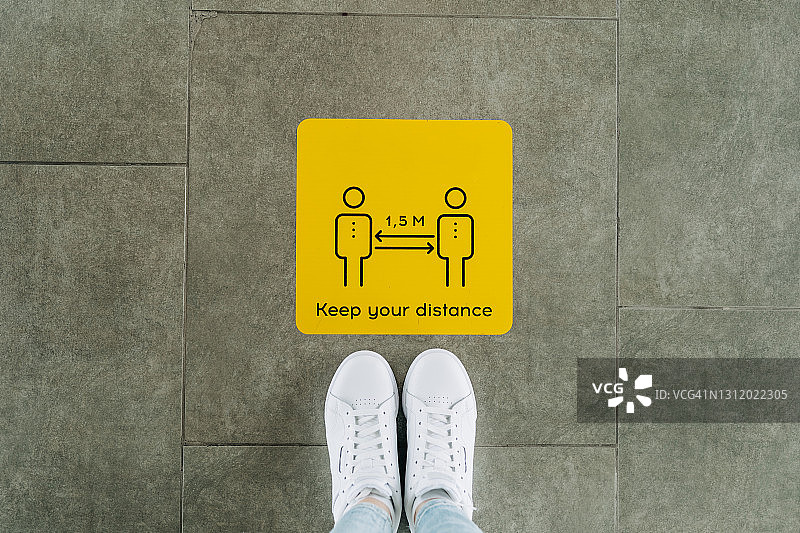 双语地板贴纸，用英语和西班牙语感谢顾客保持社交距离。新冠疫情期间使用的社交距离地板标志图片素材