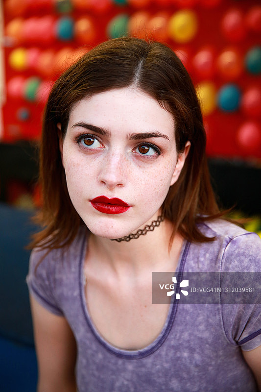 年轻女人脸色苍白，有雀斑，涂着红色口红图片素材